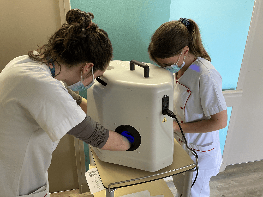 Soignants autour de caisson pour visualiser hygiène des mains